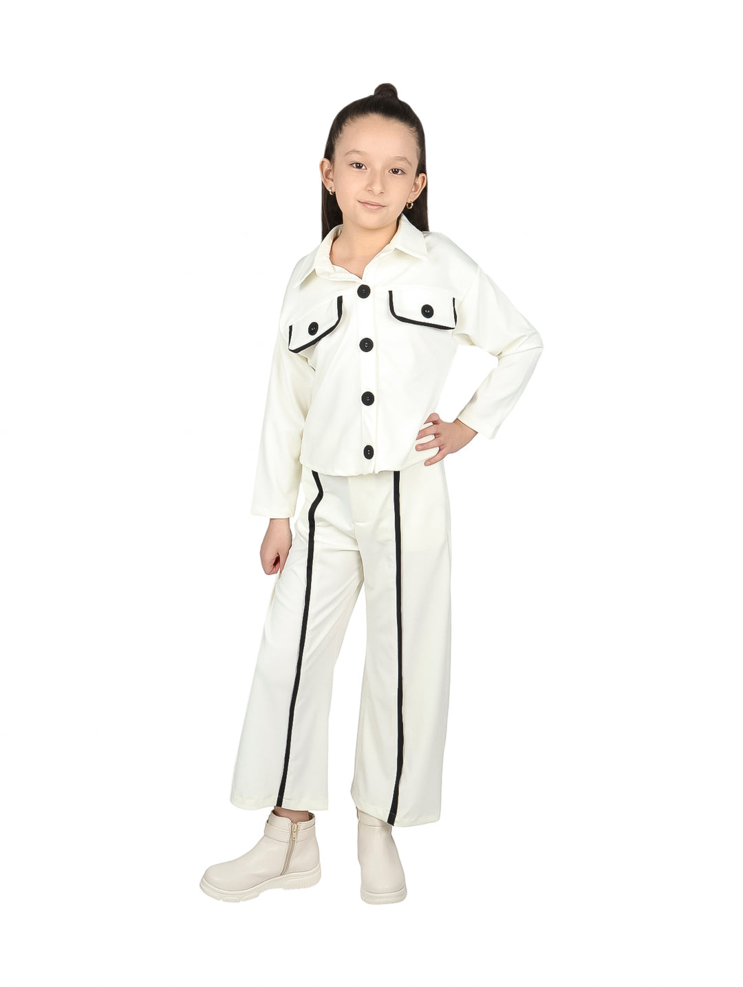 Niña vistiendo conjunto de dos piezas color crudo con detalles en negro, compuesto por chaqueta y pantalón