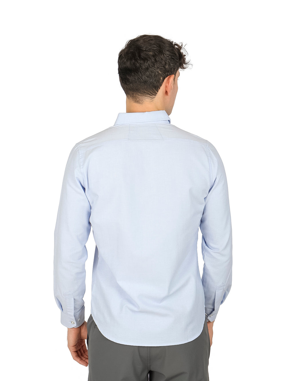Hombre vistiendo una camisa de manga larga color azul cielo lisa.