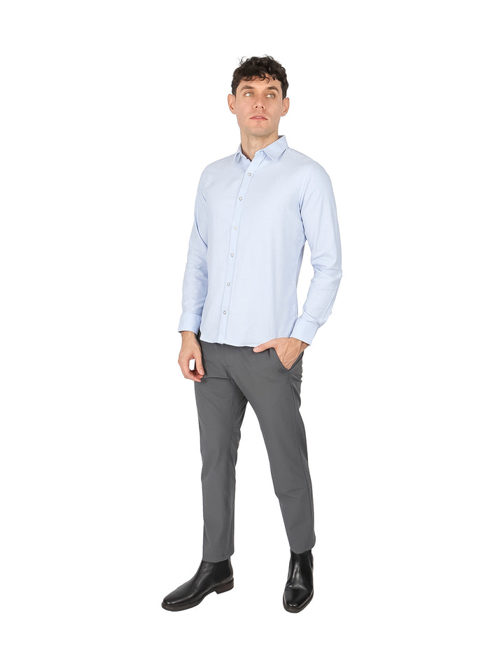 Hombre vistiendo una camisa de manga larga color azul cielo lisa.