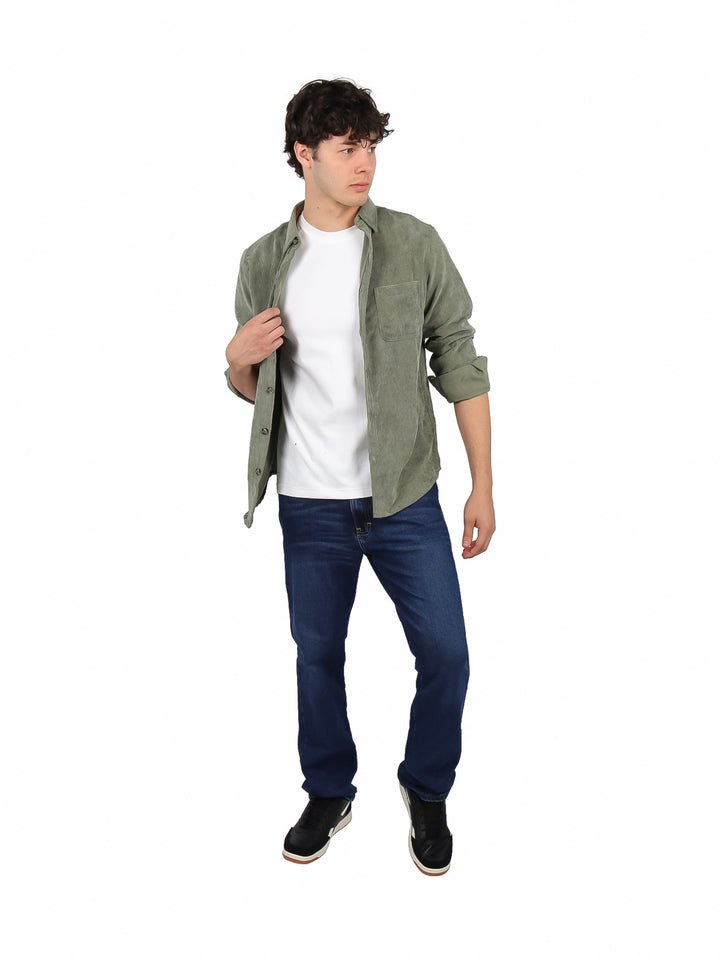 Hombre vistiendo una camisa de pana color olivo de manga larga y pantalones azules.