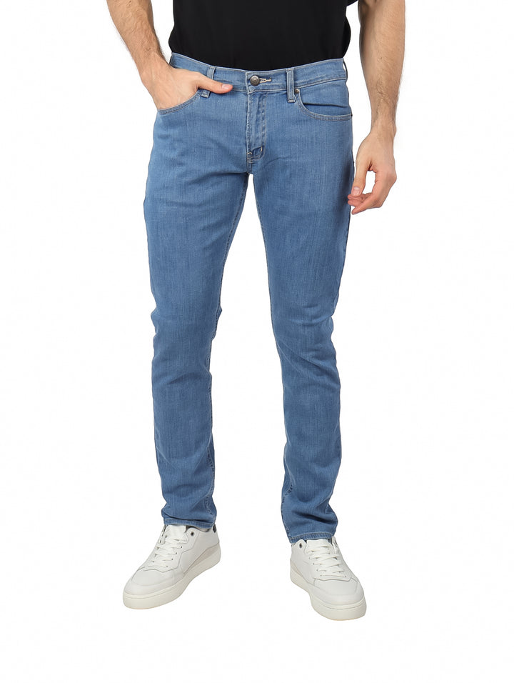 Hombre vistiendo pantalones jeans de mezclilla color azul claro con corte ajustado.