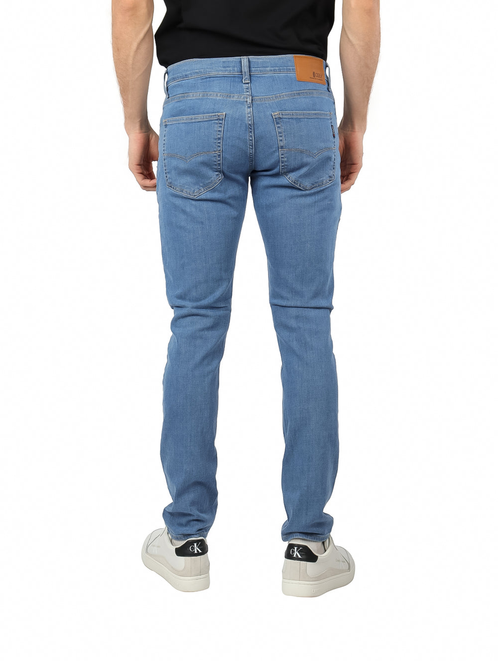 Hombre vistiendo pantalones jeans de mezclilla color azul claro con corte ajustado.