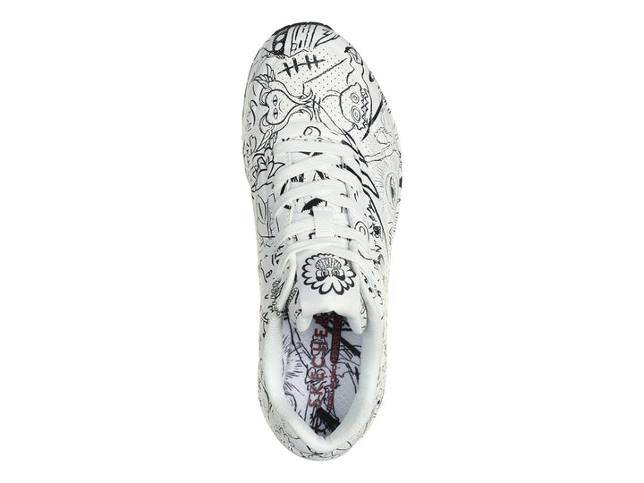 Tenis Skechers blanco con estampado de dibujos lineales en negro y suela amortiguada visible.