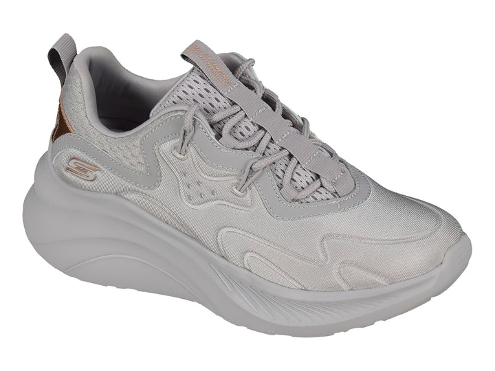 Tenis Skechers color lavanda con suela gruesa y detalles metálicos en oro rosa.