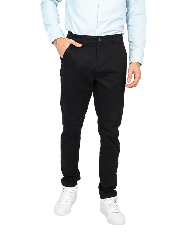 Hombre vistiendo un pantalón de gabardina color negro de corte slim fit.