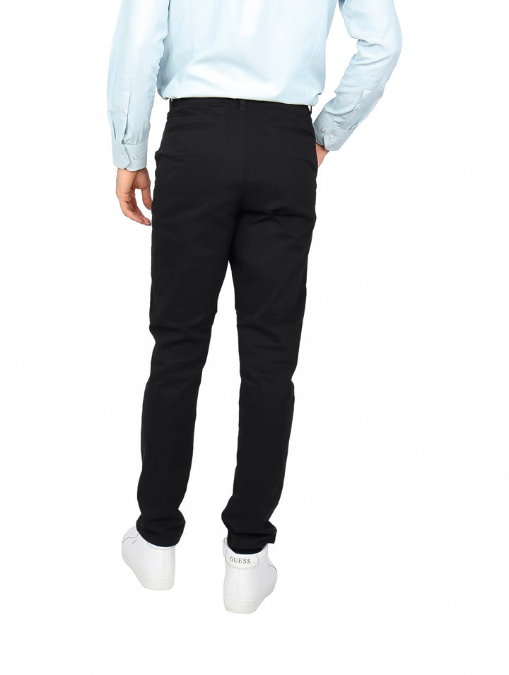 Hombre vistiendo un pantalón de gabardina color negro de corte slim fit.
