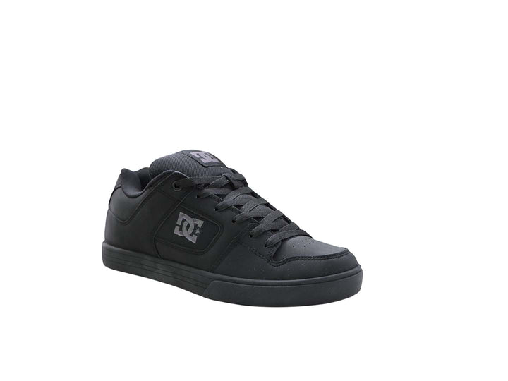 Tenis DC Shoes color negro con suela plana y logo lateral en color gris oscuro.