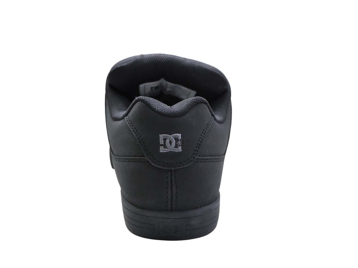 Tenis DC Shoes color negro con suela plana y logo lateral en color gris oscuro.