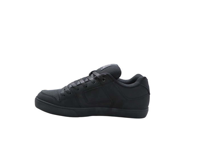 Tenis DC Shoes color negro con suela plana y logo lateral en color gris oscuro.