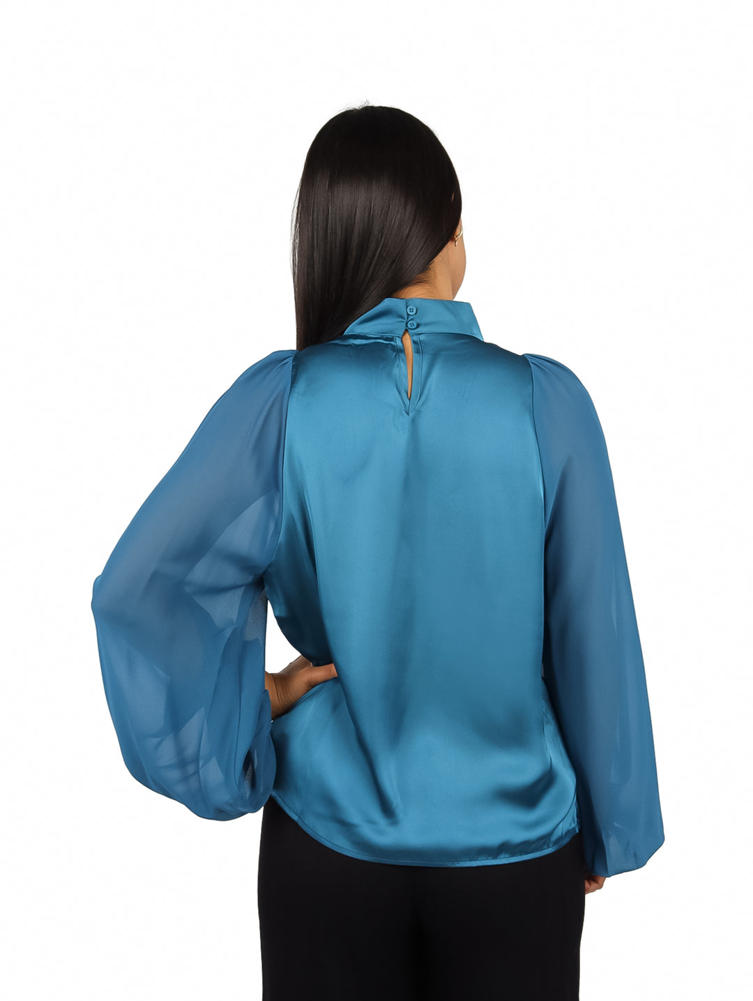 Mujer vistiendo blusa verde satinada de cuello alto y mangas largas abullonadas.