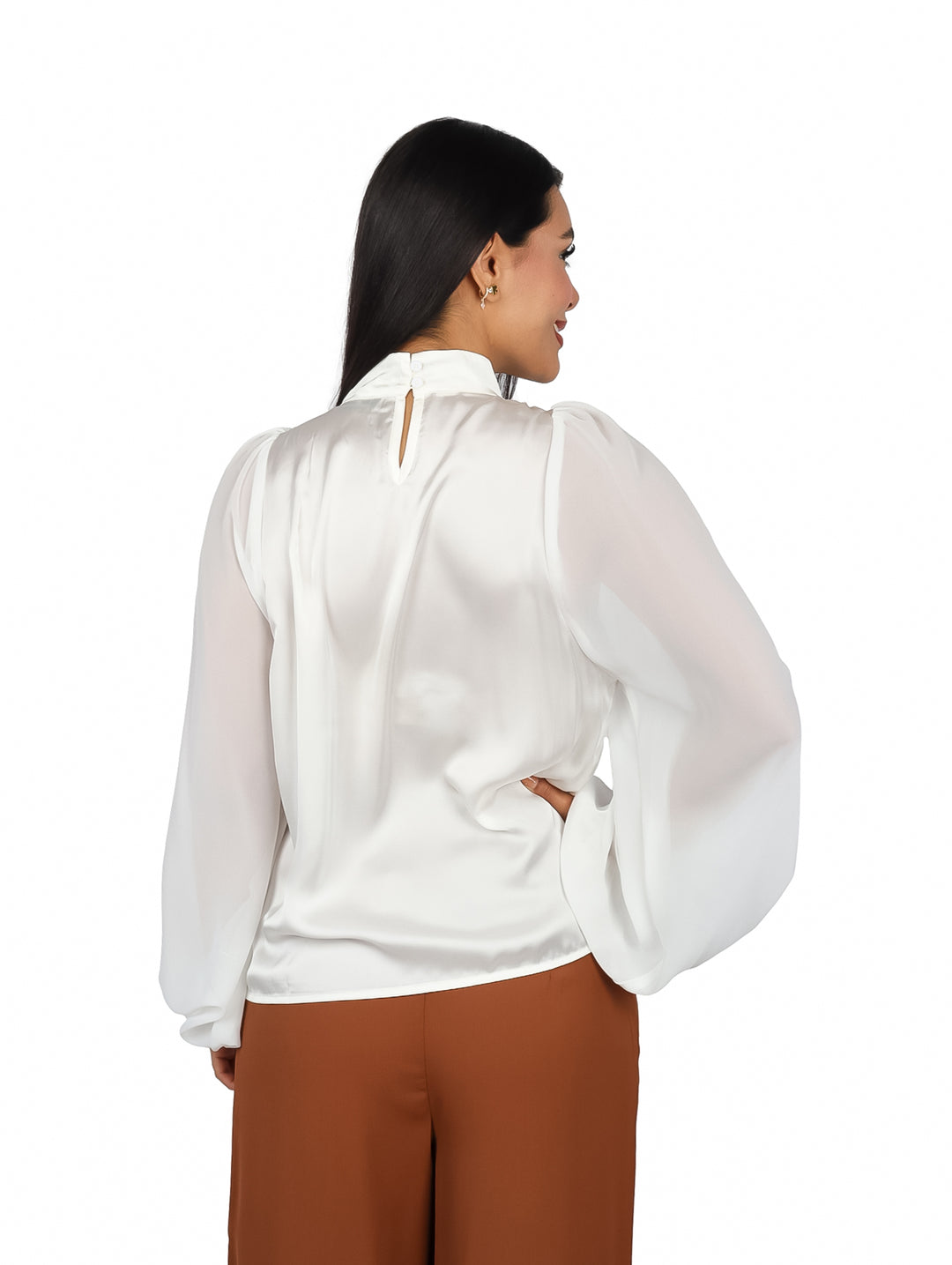 Mujer vistiendo blusa color ivory de cuello alto y mangas largas con acabado brillante.