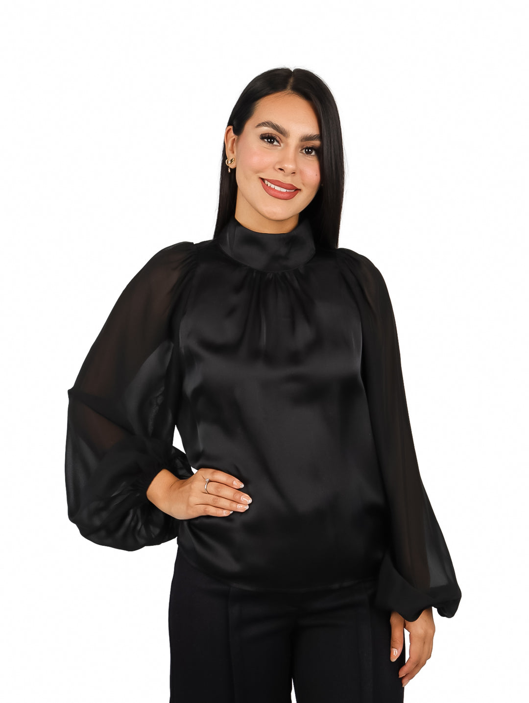 Mujer vistiendo una blusa negra elegante de cuello alto y mangas largas transparentes.