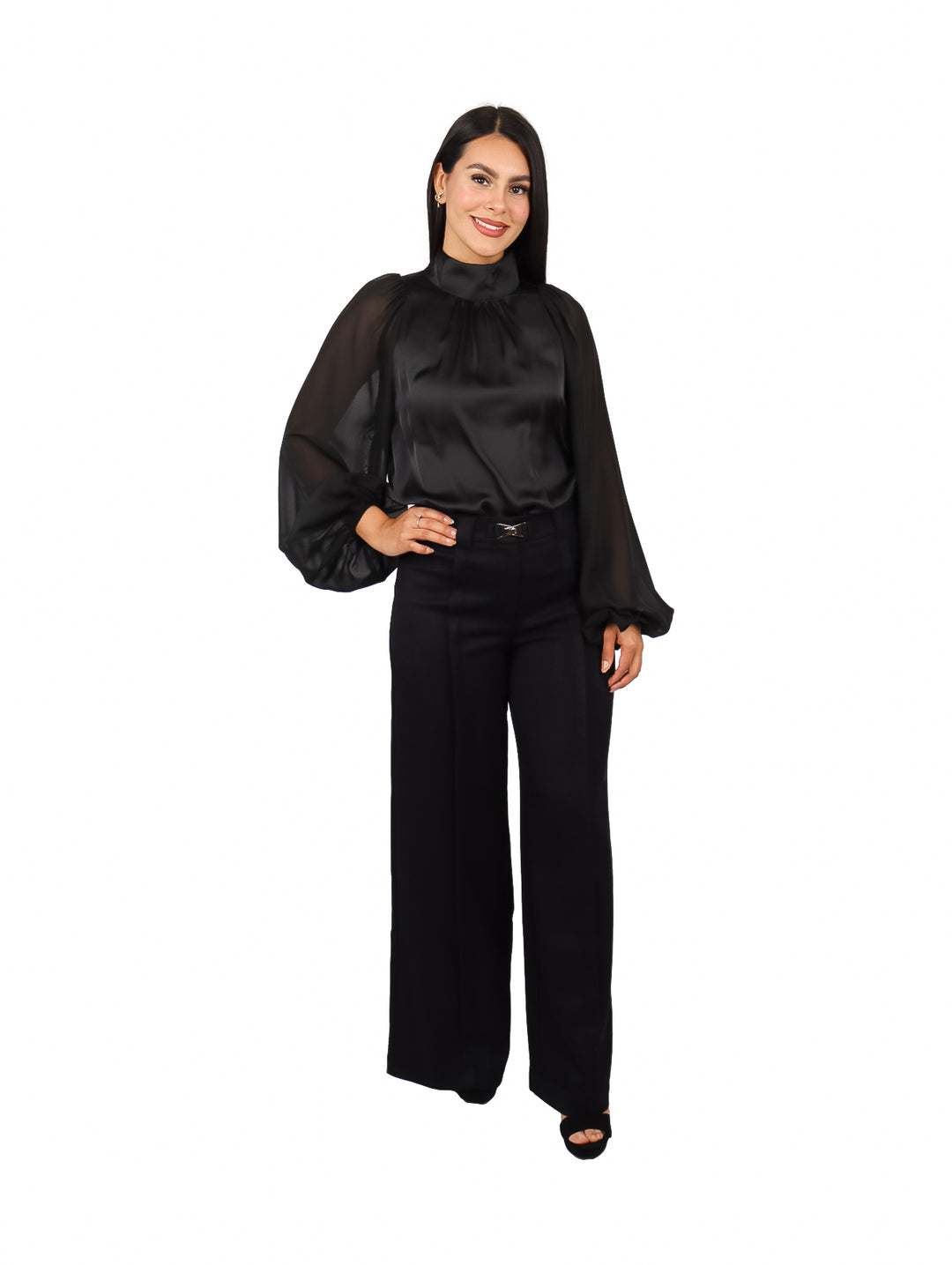 Mujer vistiendo una blusa negra elegante de cuello alto y mangas largas transparentes.