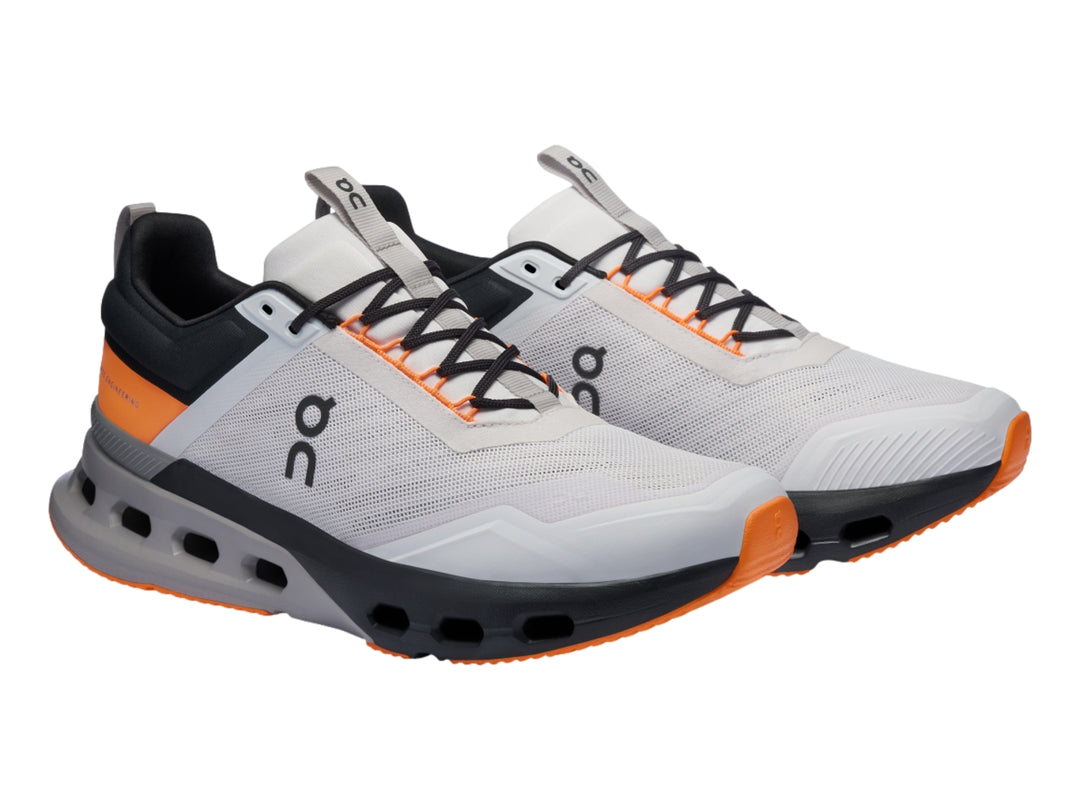Tenis deportivos On Cloud en color blanco con detalles en gris y naranja, vista lateral sobre fondo blanco.
