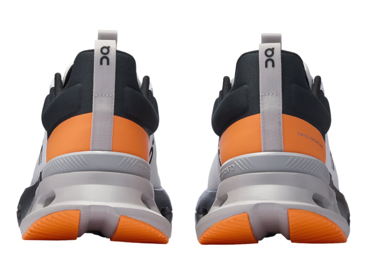 Tenis deportivos On Cloud en color blanco con detalles en gris y naranja, vista lateral sobre fondo blanco.