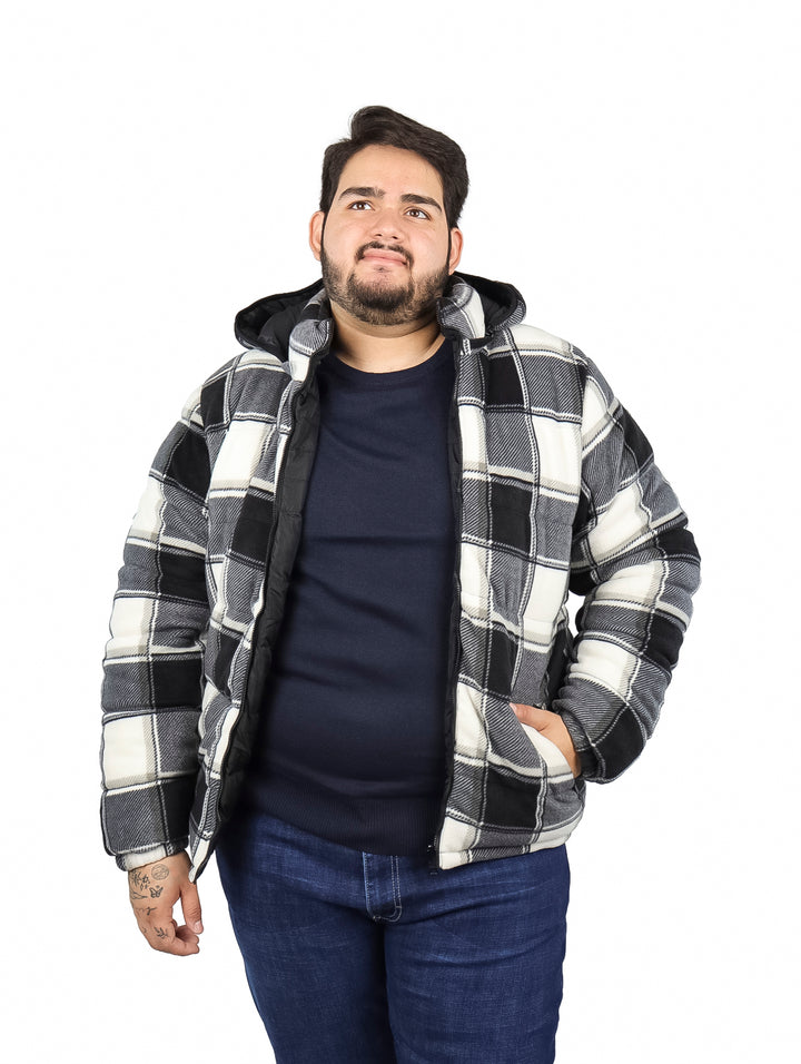 Hombre vistiendo chamarra reversible de cuadros en colores negro y blanco con capucha.
