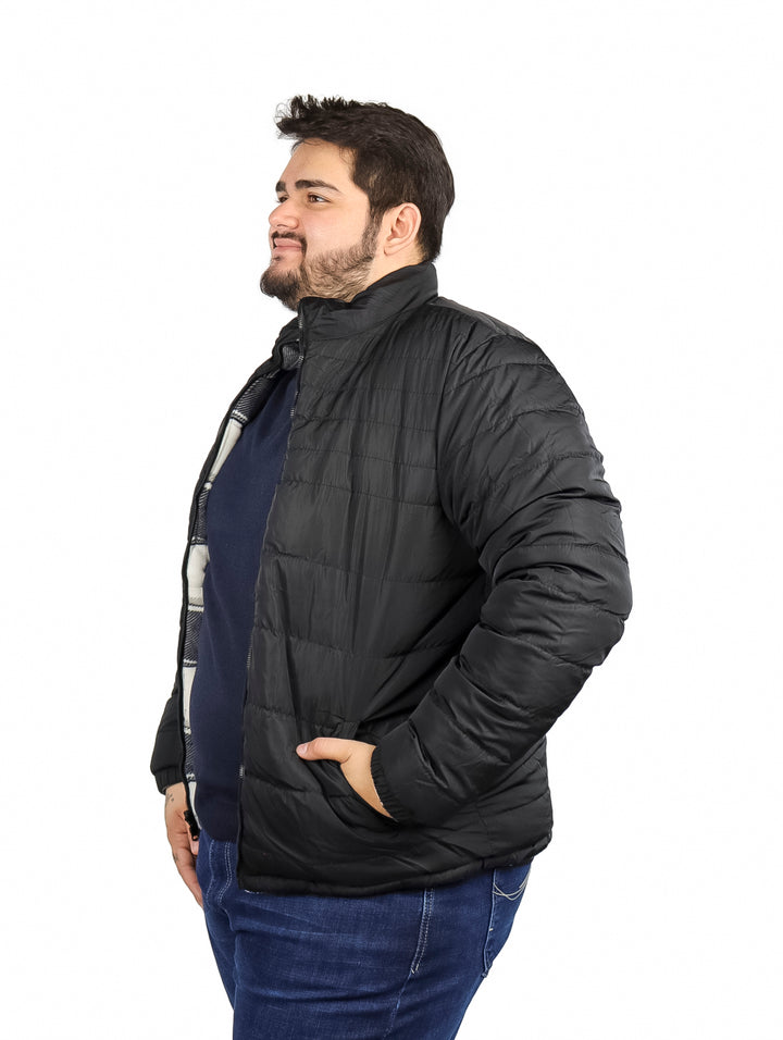 Hombre vistiendo chamarra reversible de cuadros en colores negro y blanco con capucha.