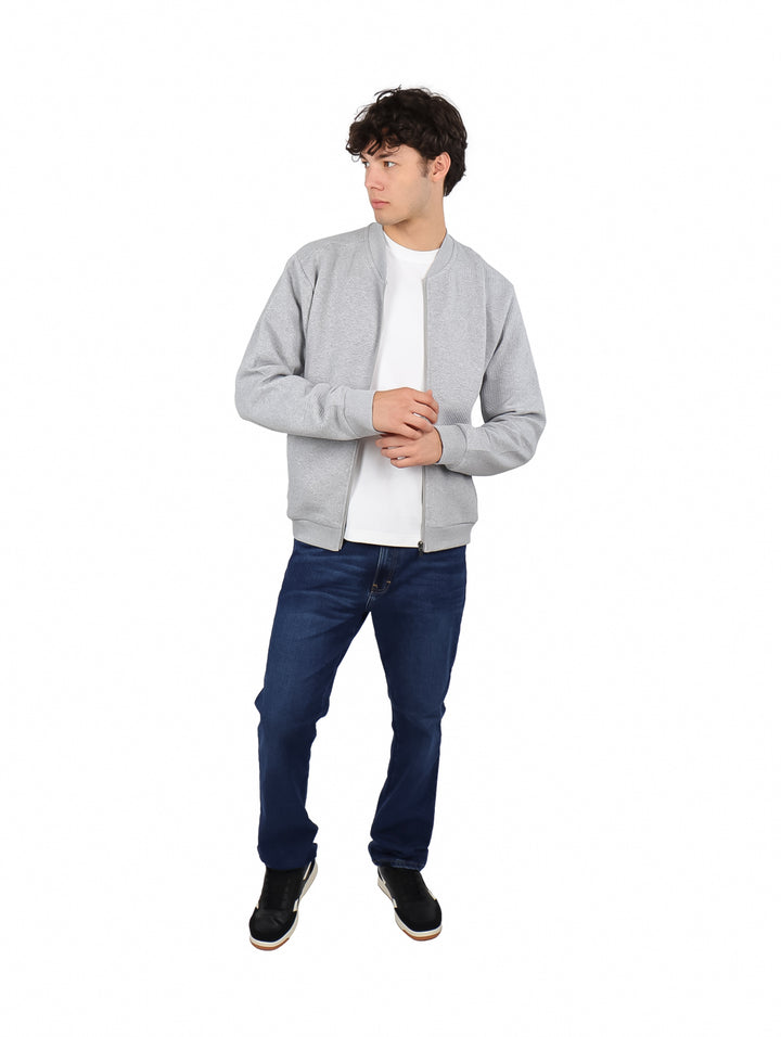 Hombre vistiendo una sudadera gris con cierre frontal y cuello redondo.