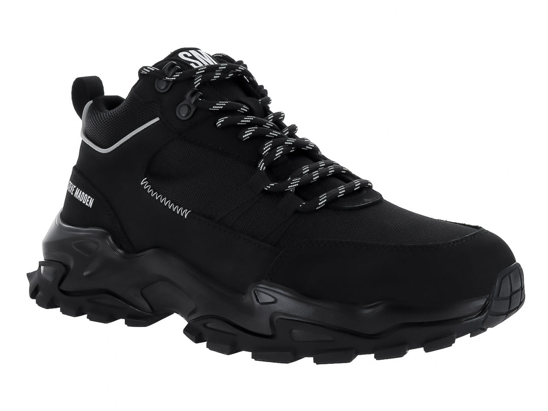 Tenis Steve Madden Henry color negro con suela gruesa y detalles en blanco.