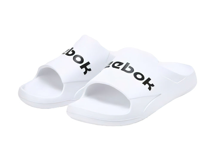 Sandalia deslizante Reebok de color blanco con logotipo negro en la banda superior.