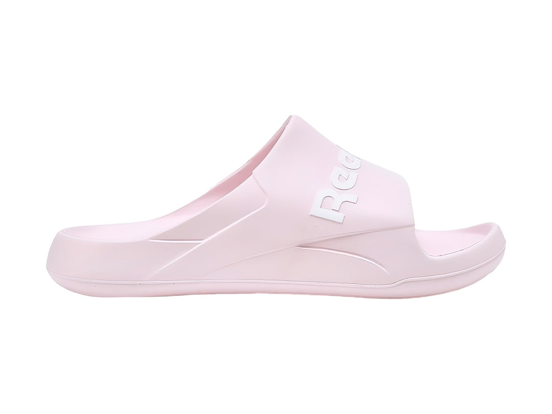 Sandalias slide Reebok en color rosa pálido con logotipo blanco en la banda superior.