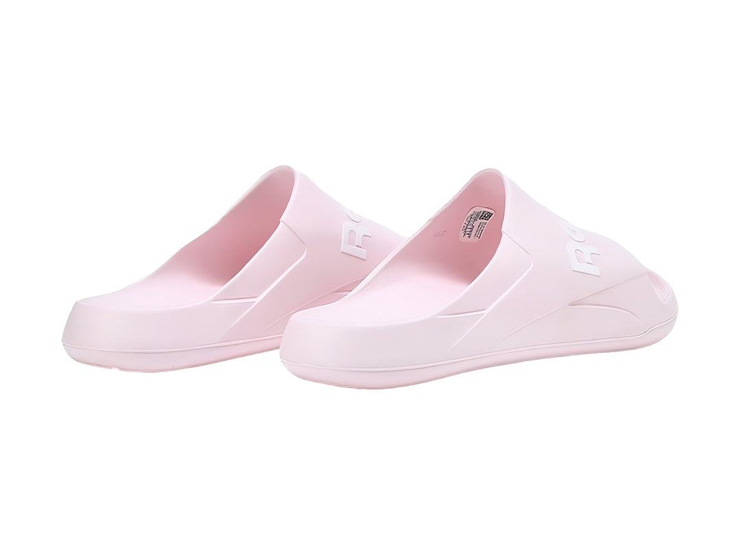 Sandalias slide Reebok en color rosa pálido con logotipo blanco en la banda superior.