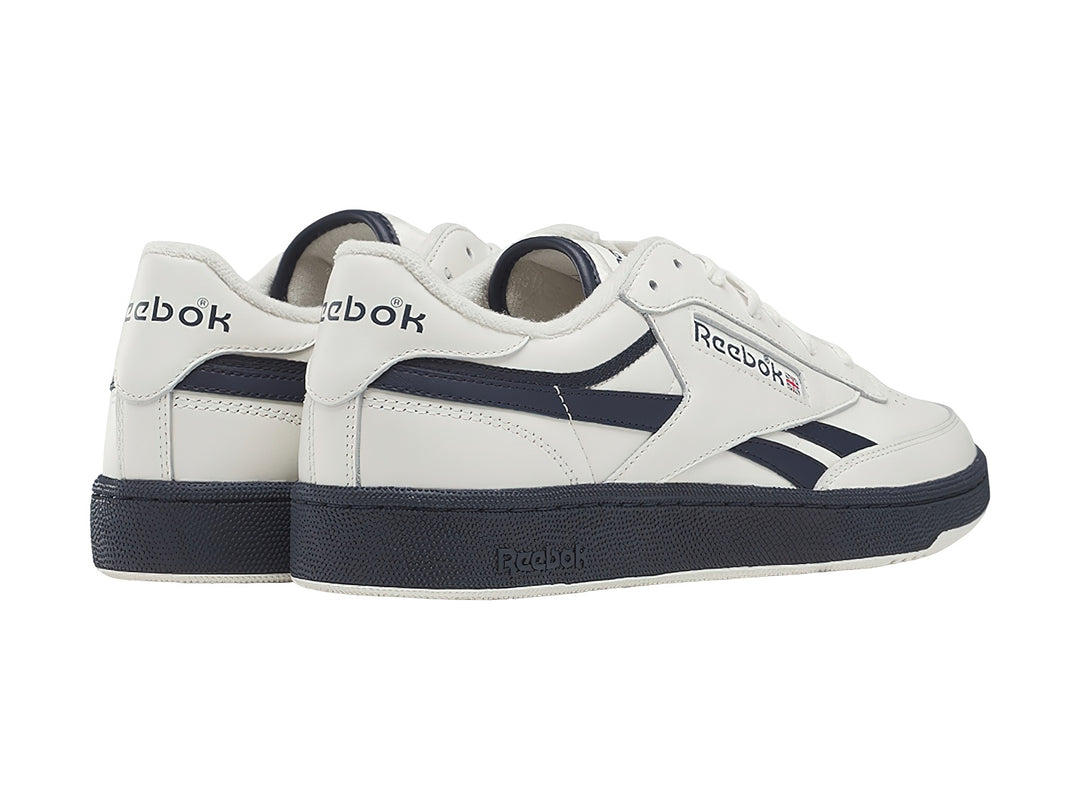 Tenis Reebok blancos con detalles y suela azul marino, estilo vintage.