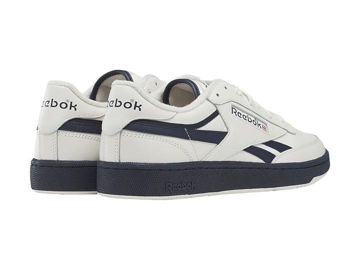 Tenis Reebok blancos con detalles y suela azul marino, estilo vintage.