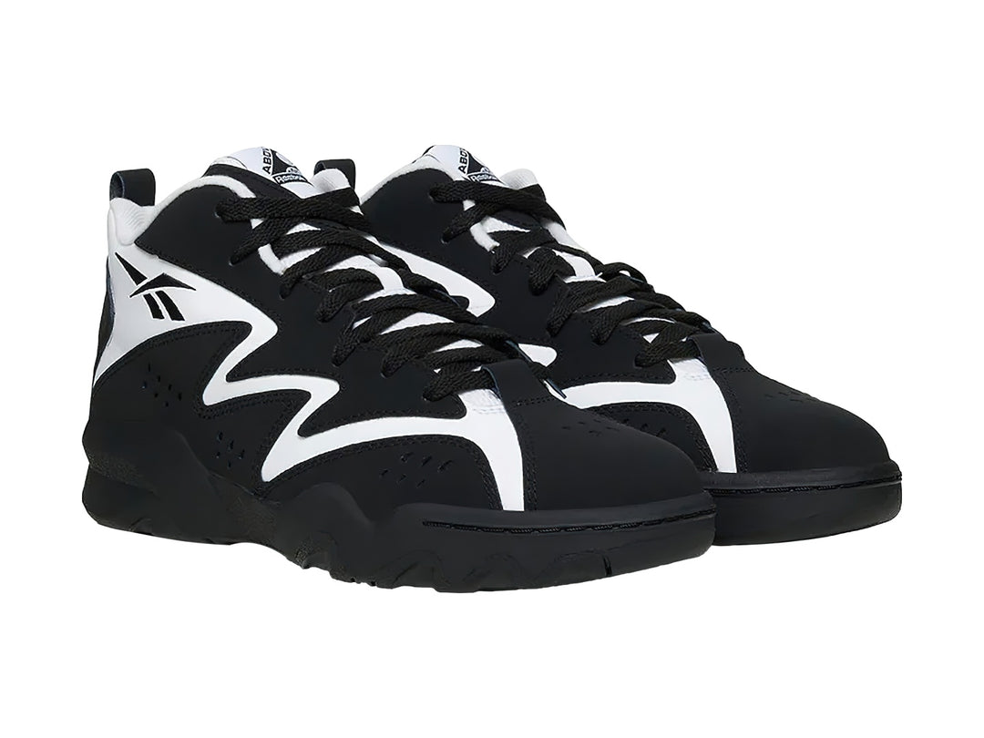 Tenis de baloncesto Reebok color negro con franjas blancas laterales y corte medio.