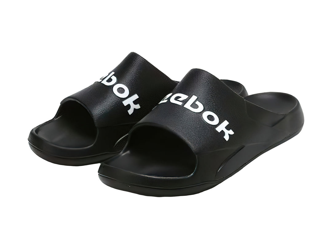 Sandalia deslizable Reebok color negro con logotipo blanco en la banda superior.