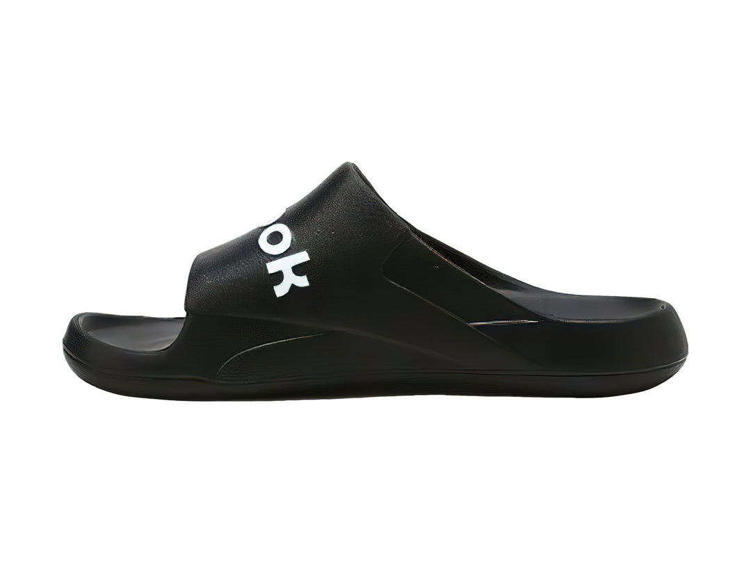 Sandalia deslizable Reebok color negro con logotipo blanco en la banda superior.