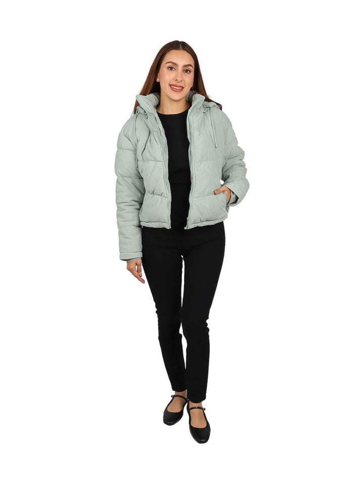 Mujer vistiendo una chamarra acolchada color menta con capucha y cierre frontal.