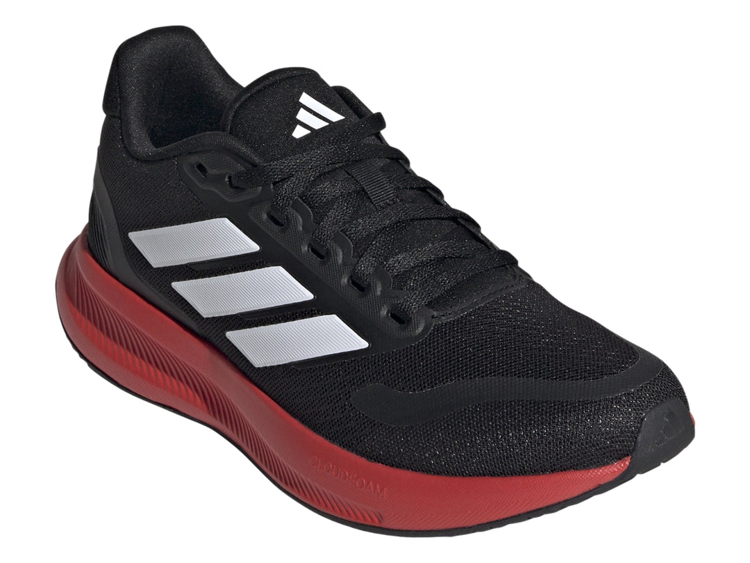 Tenis deportivos Adidas color negro con suela roja y franjas blancas laterales.