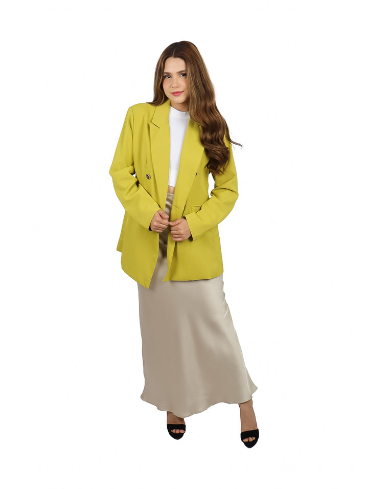 Mujer vistiendo un saco color lima con botones frontales y corte moderno.