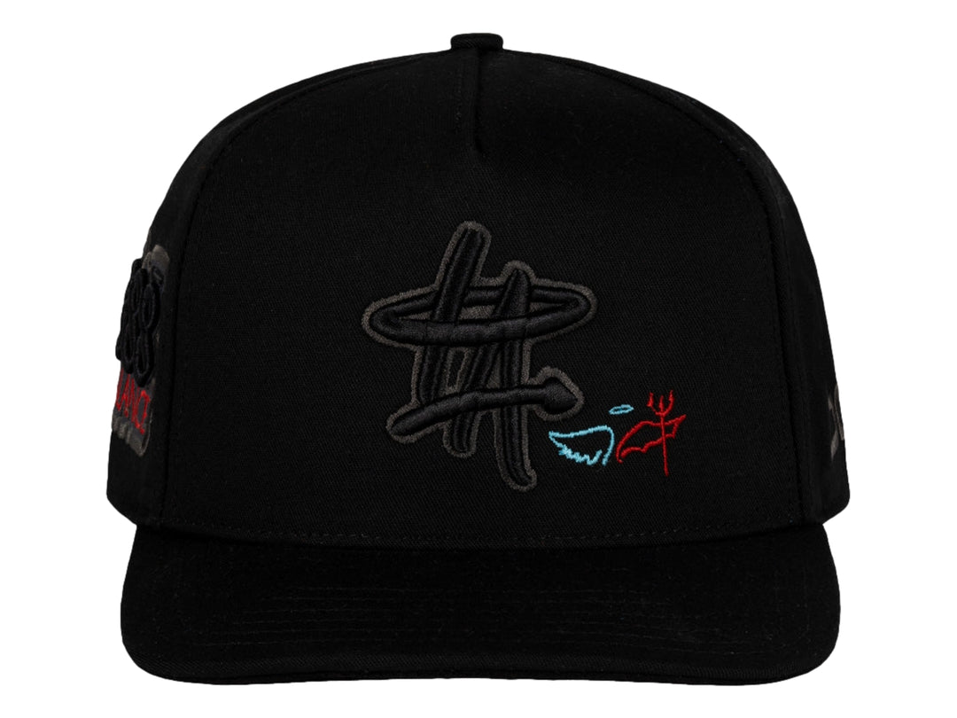 Gorra snapback color negro de la marca JC HATS con bordados decorativos en el frente y lateral.