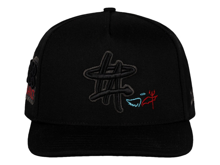 Gorra snapback color negro de la marca JC HATS con bordados decorativos en el frente y lateral.