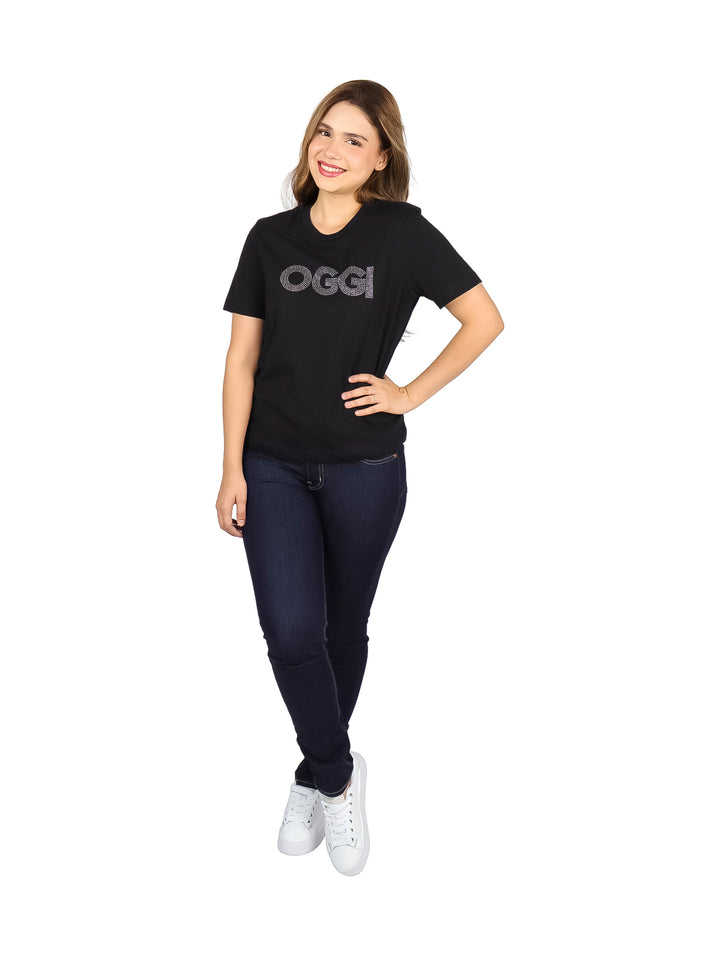 Mujer vistiendo playera deportiva negra de marca OGGI con letras brillantes en el pecho.