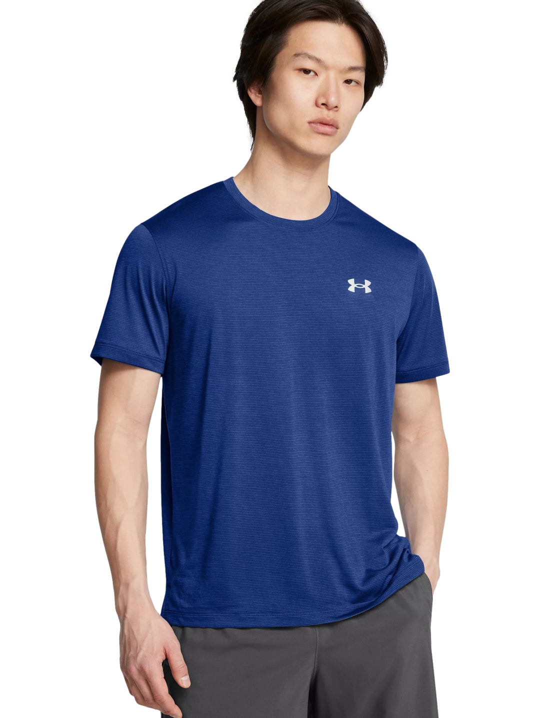 Hombre vistiendo una camiseta deportiva de manga corta color azul con logotipo blanco de Under Armour en el pecho.