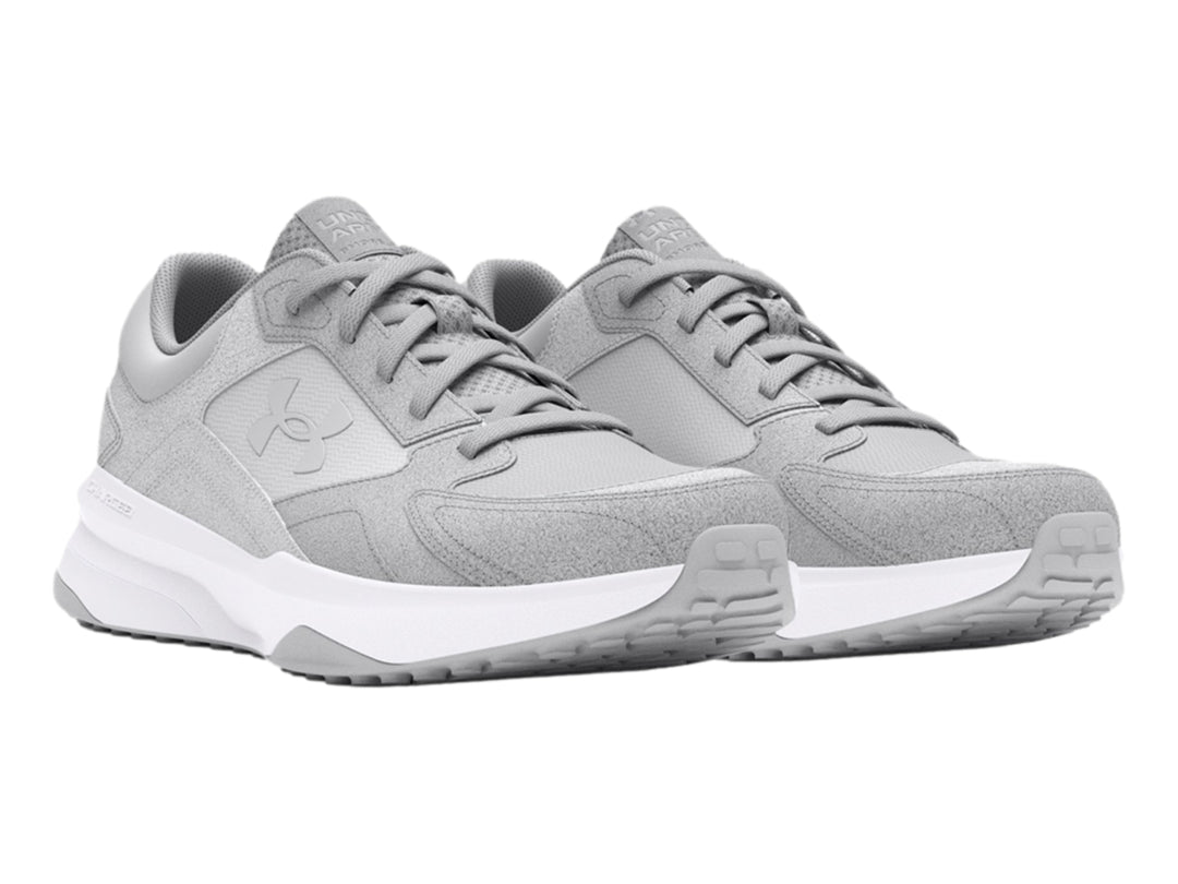 Tenis deportivos Under Armour color gris con suela blanca.