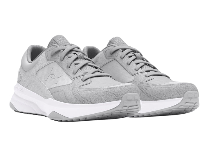Tenis deportivos Under Armour color gris con suela blanca.