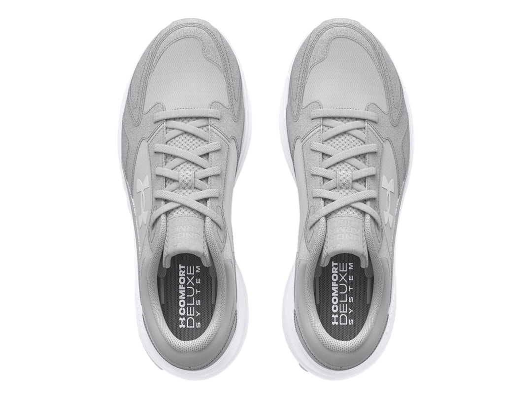 Tenis deportivos Under Armour color gris con suela blanca.