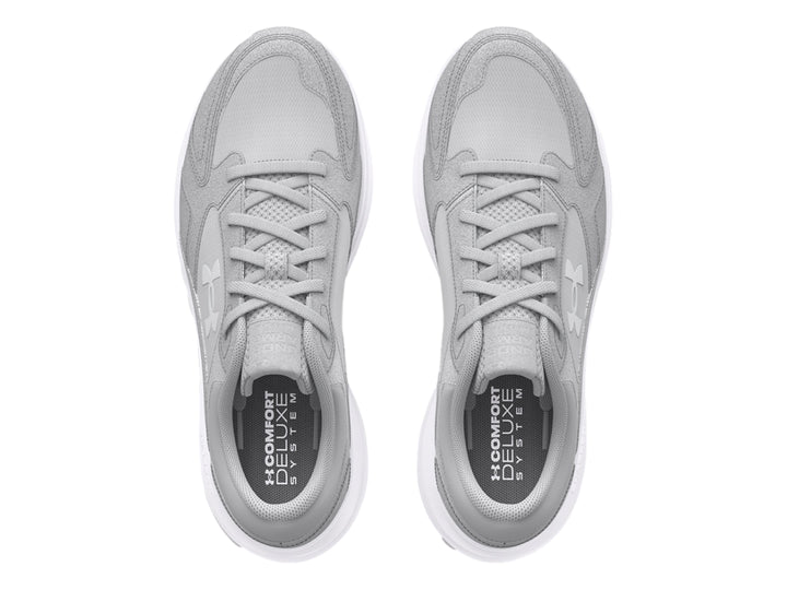 Tenis deportivos Under Armour color gris con suela blanca.