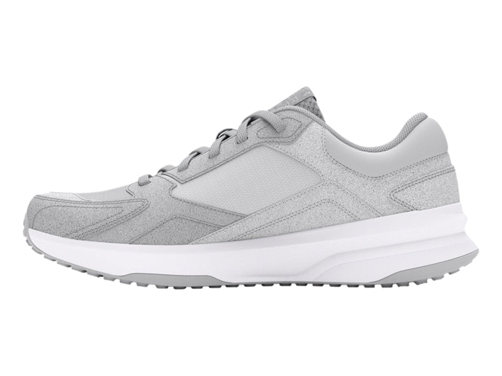 Tenis deportivos Under Armour color gris con suela blanca.
