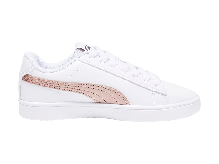 Tenis PUMA Rickie Classic Jr en color blanco con franja lateral en tono oro rosa y suela blanca.