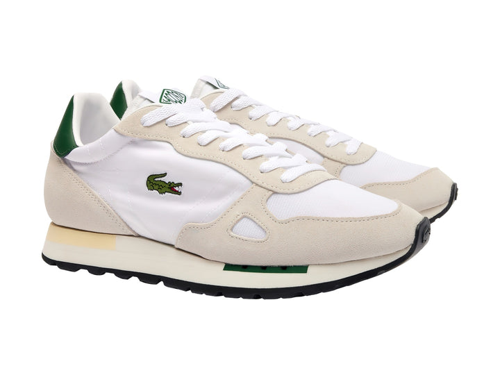 Tenis Lacoste blancos y beige con detalles en verde oscuro y suela blanca.