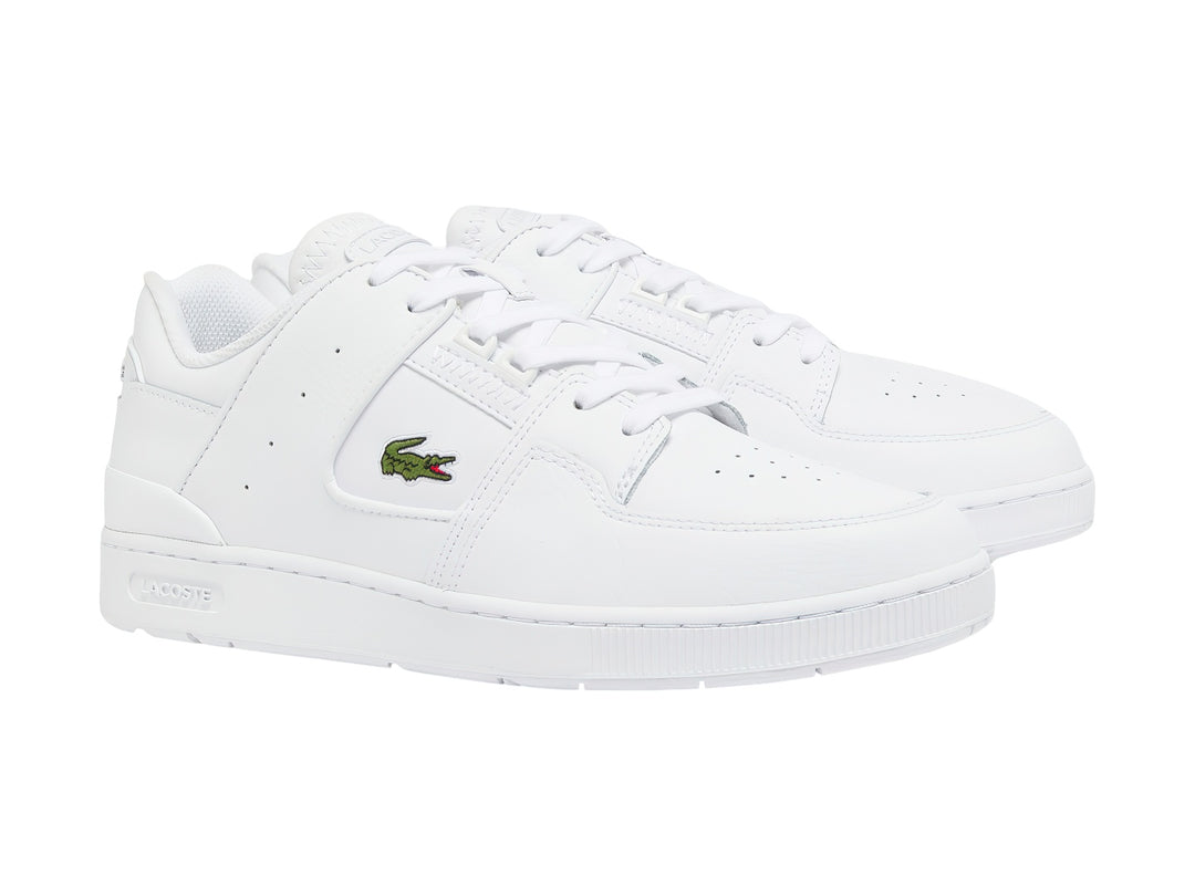 Tenis blancos de cuero Lacoste con logotipo de cocodrilo verde en el lateral.
