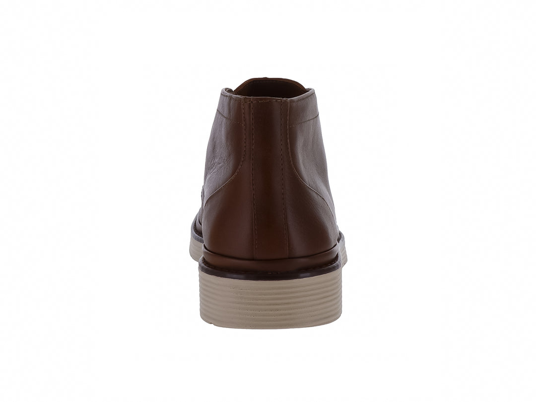 Zapato botín de cuero color marrón con suela blanca y cordones.