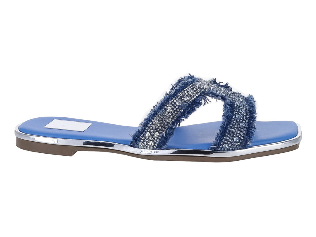 Sandalia plana azul con tiras brillantes plateadas y borde de suela plateado.