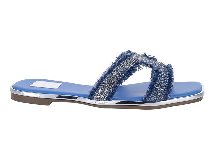 Sandalia plana azul con tiras brillantes plateadas y borde de suela plateado.
