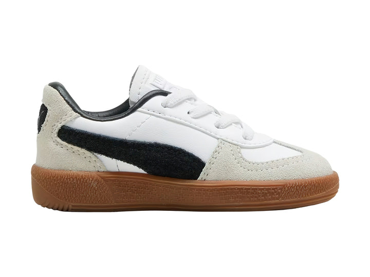 Tenis PUMA Palermo para bebé en color blanco con detalles en gris y negro y suela de goma café.